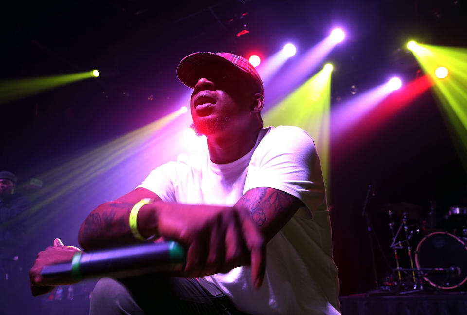 Mick Jenkins kneels on stage during a performance.