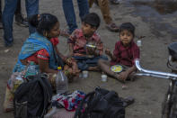 Children of daily wage laborers eat breakfast as their parents wait to get hired in Mumbai, India, Wednesday, Feb. 1, 2023. Indian Prime Minister Narendra Modi's government ramped up capital spending by a substantial 33% to $122 billion in an annual budget presented to Parliament on Wednesday, seeking to spur economic growth and create jobs ahead of a general election next year. (AP Photo/Rafiq Maqbool)