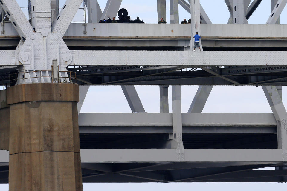 Sylvester Holt pleads with officers while standing on a ledge of the Crescent City Connection Friday, Jan. 20, 2017, in New Orleans. Holt was wanted in the connection with the shooting of his wife and a Westwego police officer. (AP Photo/Jonathan Bachman)