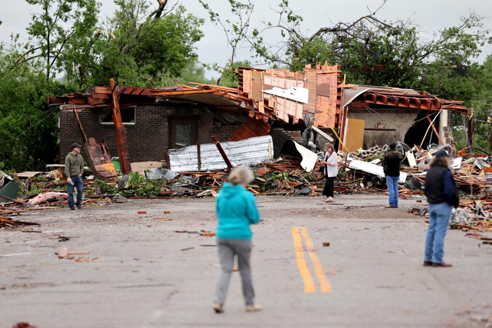 People look at tornado damage in Sulphur, Okla., Sunday, April 28, 2024, after severe storms hit the area the night before.