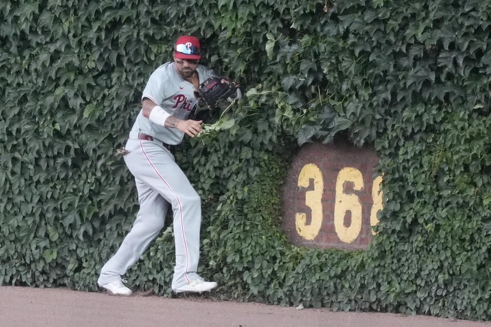 Philadelphia Phillies' Nick Castellanos bounces off the right field wall after catching a deep fly ball by Chicago Cubs' Cody Bellinger during the first inning of a baseball game Tuesday, July 2, 2024, in Chicago. (AP Photo/Charles Rex Arbogast)