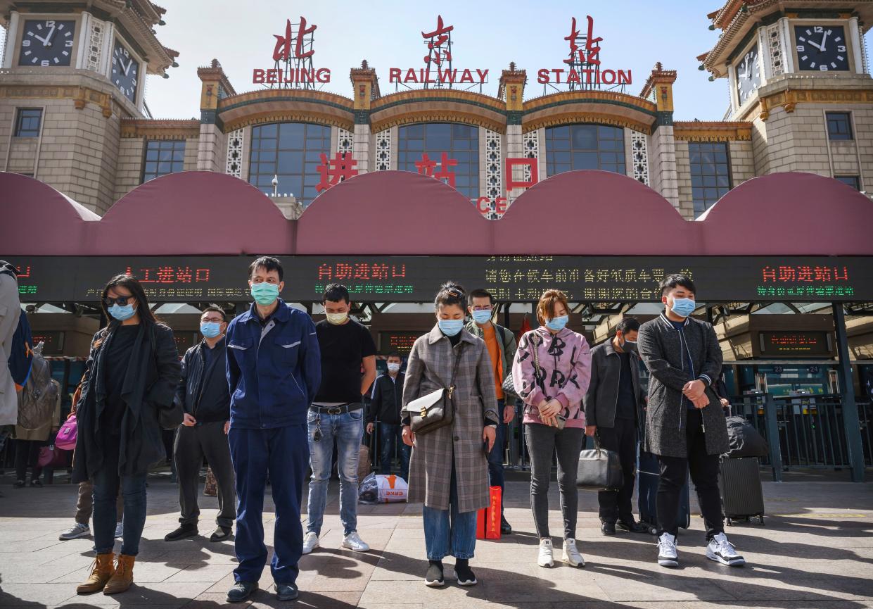 Chinese travellers wear protective masks as they bow their heads at 10 a.m. for three minutes of silence to mark the country's national day of mourning for COVID-19 victims at Beijing Railway Station on April 4, 2020, in Beijing, China. Across the country people paused, and sirens and horns wailed for three minutes to remember medical personnel and patients who died during the coronavirus outbreak. With the pandemic hitting hard across the world, officially the number of coronavirus cases in China is dwindling, since the government imposed sweeping measures to keep the disease from spreading.