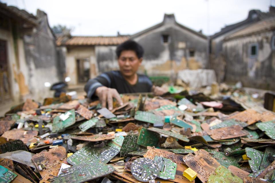 A worker in China sorts through stripped computer boards. (Photo: Jim Xu/Getty Images)