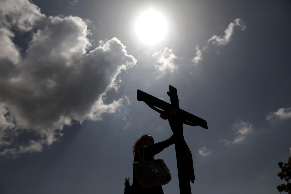 An Orthodox faithful touches a crucifix before a Good Friday reenactment of Deposition of Jesus Christ, at Penteli Monastery, near Athens Greece. 