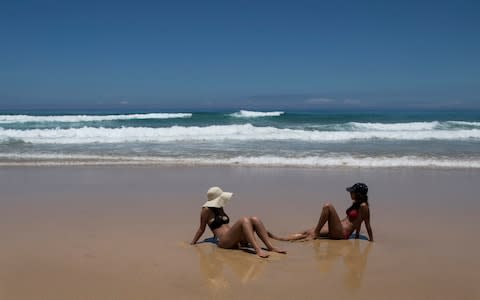 A sunbathers basks in the hot sun on the Cofete beach at the Atlantic Ocean on the Canary Island of Fuerteventura, Spain - Credit: AP