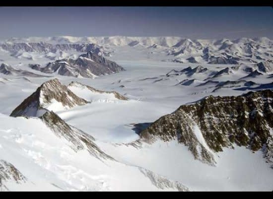 Intricate ridgelines populate the central drainage of Amundsen Glacier, flowing from left to right in the middle ground.  At the horizon, Rawson Plateau marks the boundary of the polar plateau.  