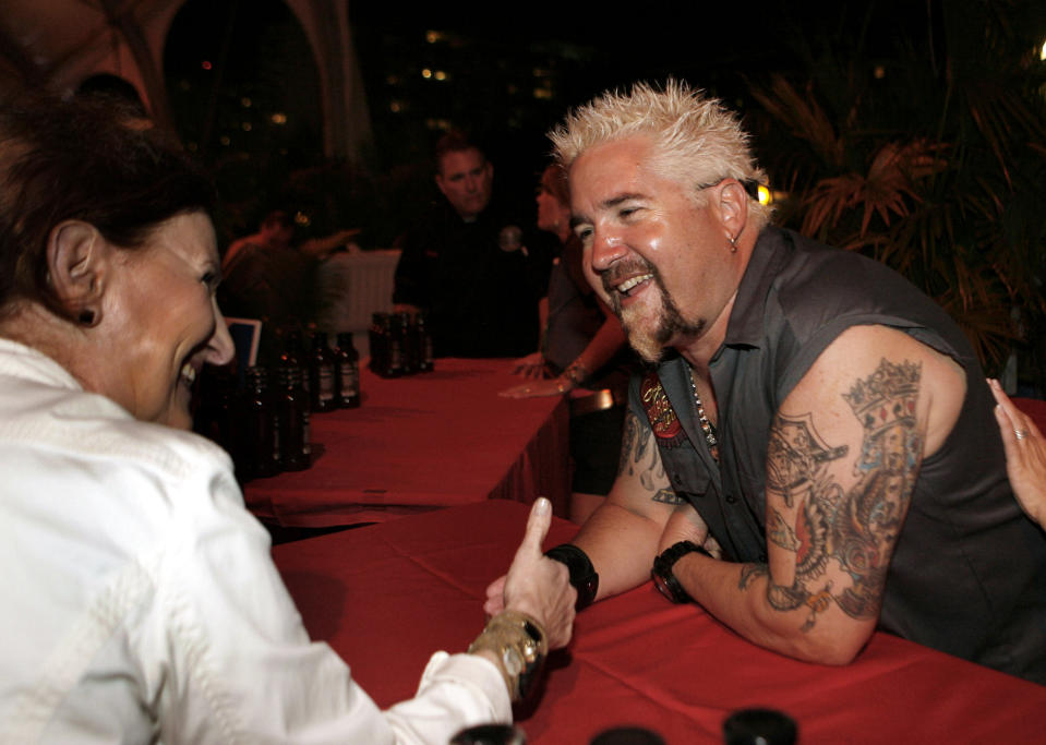 Food network personality Guy Fieri greets fans while competing in the Burger Bash at the Food Network South Beach Wine & Food Festival in Miami Beach, Fla., Friday, Feb. 24, 2012. (AP photo/Jeffrey M. Boan)