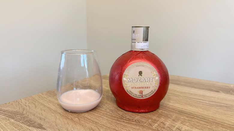 Glass and bottle of Mozart strawberry liqueur