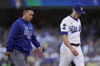 Los Angeles Dodgers pitcher Joe Kelly leaves the mound with a trainer during the first inning against the Atlanta Braves in Game 5 of baseball's National League Championship Series Thursday, Oct. 21, 2021, in Los Angeles. (AP Photo/Jae C. Hong)