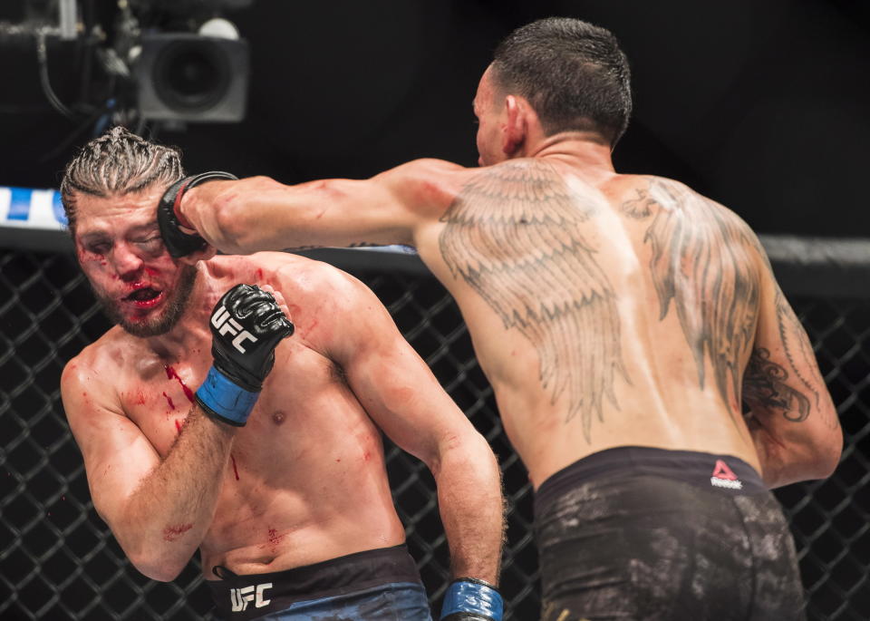 Max Holloway, right, hits Brian Ortega during the featherweight championship mixed martial arts bout at UFC 231 in Toronto on Saturday, Dec. 8, 2018. (Nathan Denette/The Canadian Press via AP)