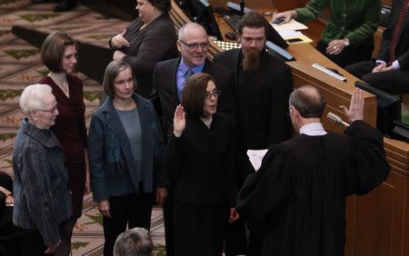 Oregon Governor Kate Brown is sworn in, surrounded by family members, at the state capital building in Salem, Oregon February 18, 2015. REUTERS/Steve Dipaola