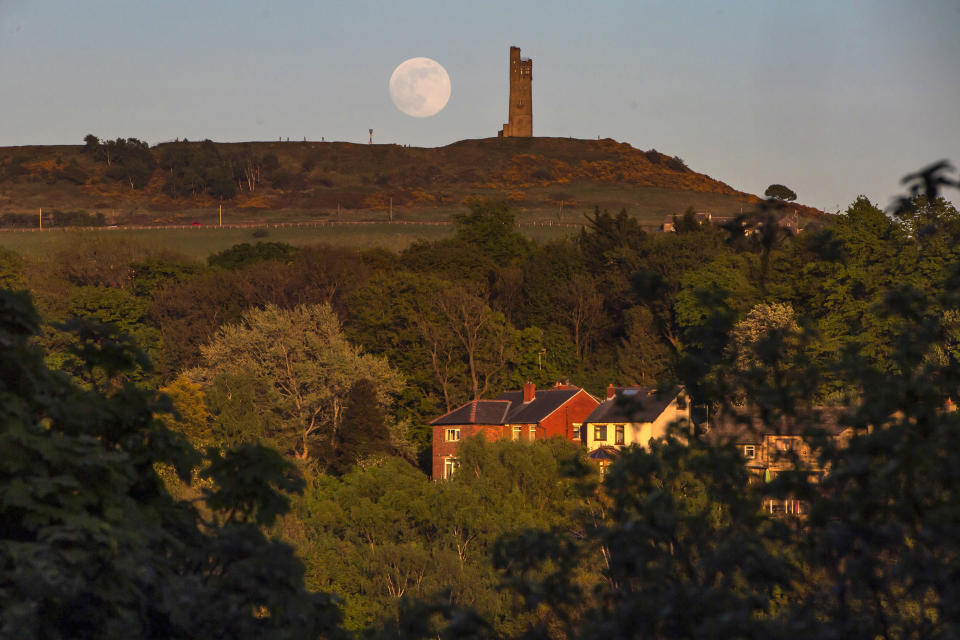 The Flower Moon is seen 99% full as it rises behind Victoria Tower on Castle Hill  in Huddersfield.