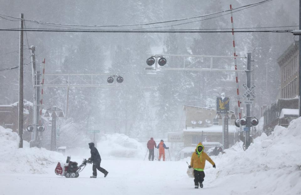 TRUCKEE, CALIFORNIA - MARCH 02: People make their way through downtown on foot and on skis as snow falls north of Lake Tahoe during a powerful multiple day winter storm in the Sierra Nevada mountains on March 02, 2024 in Truckee, California. Blizzard warnings were issued with snowfall of up to 12 feet and wind gusts over 100 mph expected in some higher elevation locations. Yosemite National Park is closed and a 50-mile stretch of Interstate 80 was shut down yesterday due to the storm. (Photo by Mario Tama/Getty Images) ORG XMIT: 776114505 ORIG FILE ID: 2053559761