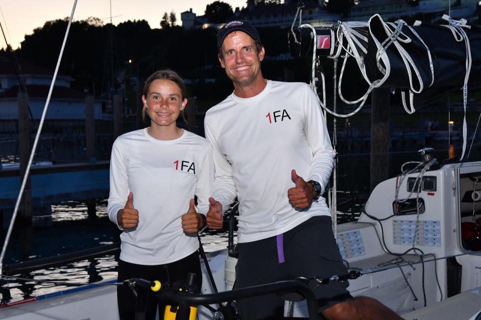 Merritt Sellers, 14, and her father Scott Sellers, of Larkspur, Calif., finished the Bayview Mackinac Race to cheers from a crowd at the Pink Pony on Mackinac Island. They had been up more than 30 hours and said they needed sleep and cheeseburgers.