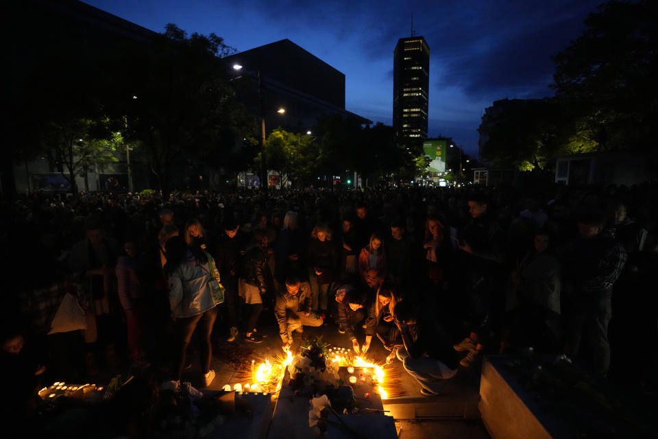 People light candles for the victims near the Vladislav Ribnikar school in Belgrade, Serbia, Wednesday, May 3, 2023. Police say a 13-year-old who opened fire at his school drew sketches of classrooms and made a list of people he intended to target. He killed eight fellow students and a school guard before being arrested. (AP Photo/Darko Vojinovic)