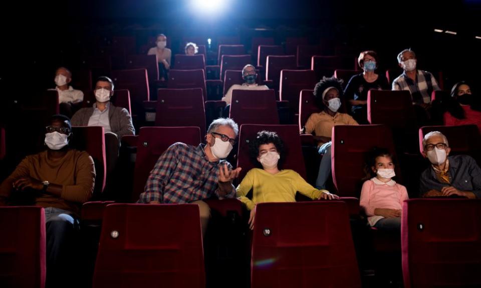 A movie audience dons masks.