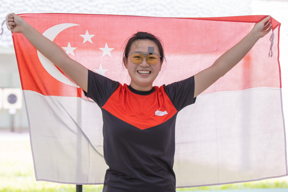 Singapore shooter Teh Xiu Hong holds up the national flag after winning gold in the women's 25m pistol event at the Hanoi SEA Games. (PHOTO: Sport Singapore/ Dyan Tjhia)