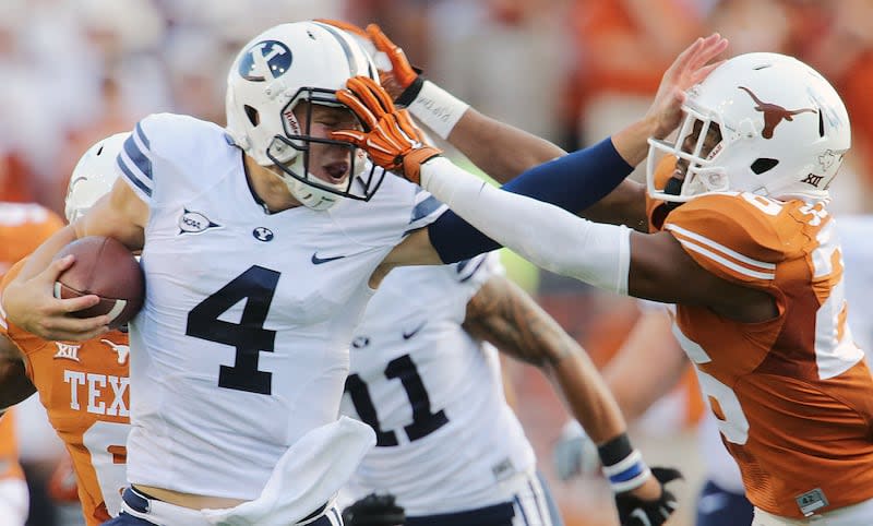 BYU’s quarterback Taysom Hill pushes Texas’ Adrian Colbert away on a run that was called back as BYU and Texas play in 2014.