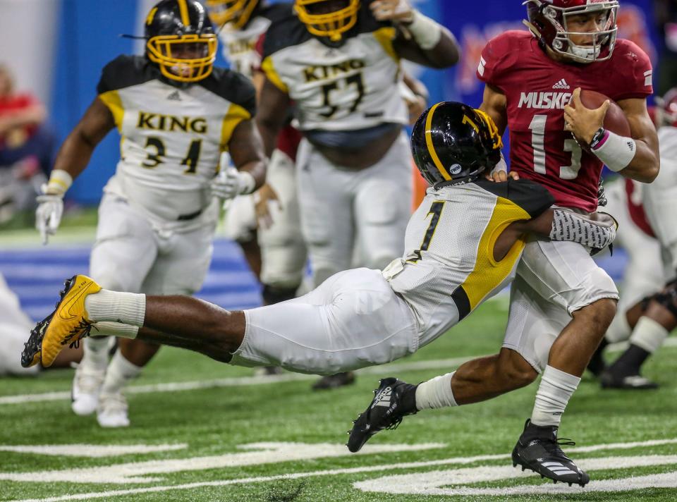 Detroit King's Ray Williams wraps up Muskegon quarterback Cameron Martinez during the Division football state title at Ford Field on Saturday, Nov. 24, 2018.