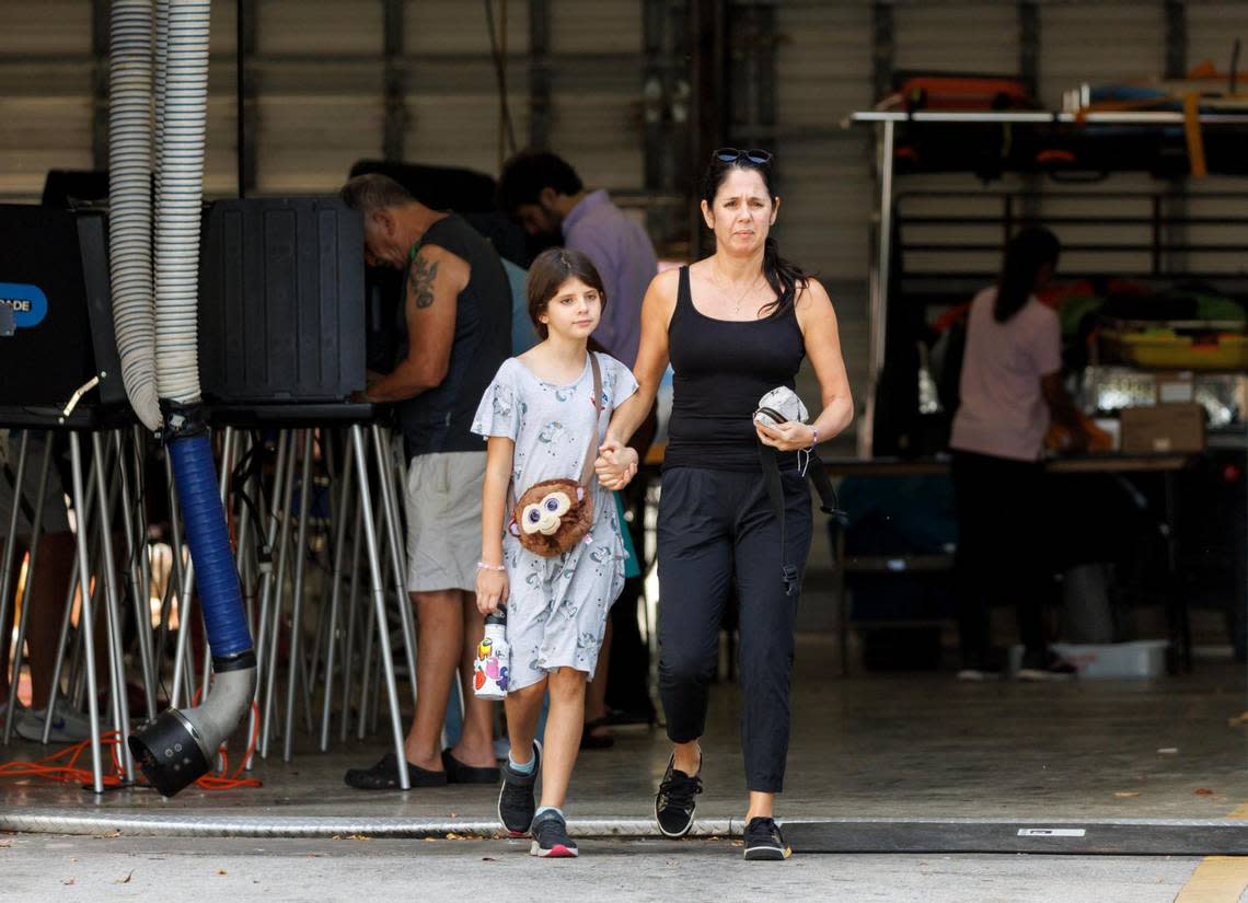 Alicia Aloise walks with her daughter Helena Eloise, 9, after casting her ballot at the Miami Beach Fire Department - Station 3 on Tuesday, Nov. 8, 2022, in Miami Beach, Florida.
