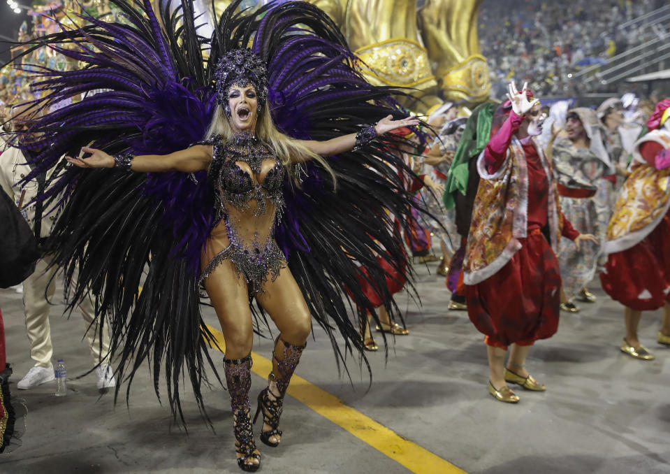 Transgender godmother Camila Prins from the Colorado do Bras samba school performs during a Carnival parade in Sao Paulo, Brazil, Sunday, Feb. 23, 2020. Prins entered the parade grounds, in a costume of feathers that displayed her sinuous body, fulfilling a dream nearly three decades old. (AP Photo/Andre Penner)