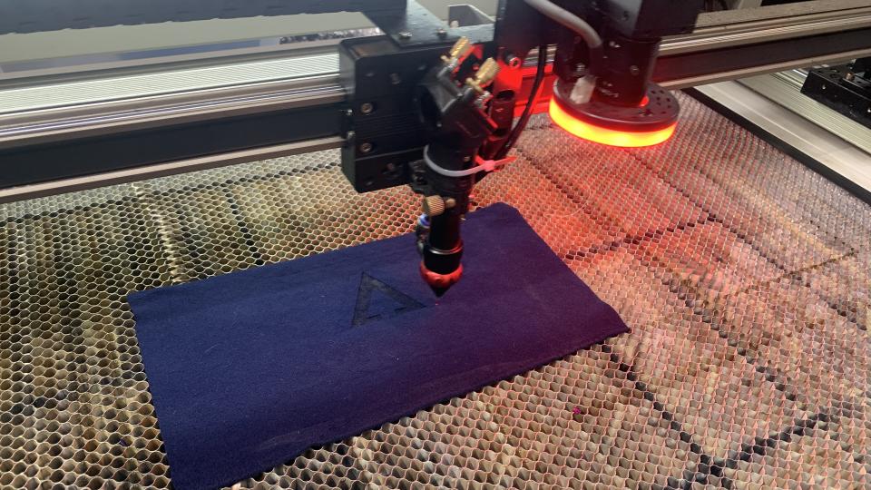 Laser machine embossing Advnture logo on fabric