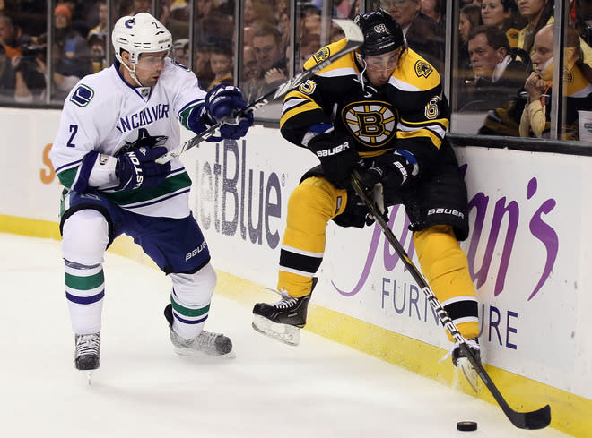 BOSTON, MA - JANUARY 07: Brad Marchand #63 of the Boston Bruins tries to keep the puck as Dan Hamhuis #2 of the Vancouver Canucks defends on January 7, 2012 at TD Garden in Boston, Massachusetts. (Photo by Elsa/Getty Images)