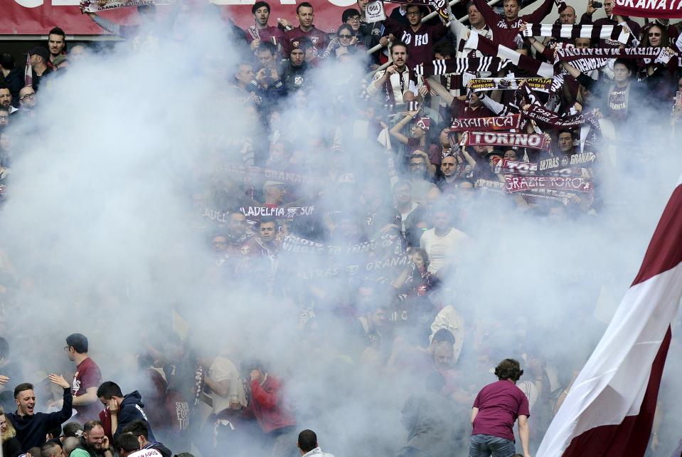 Torino's supporters look on as a firework explode during their Italian Serie A soccer match against Juventus in Turin