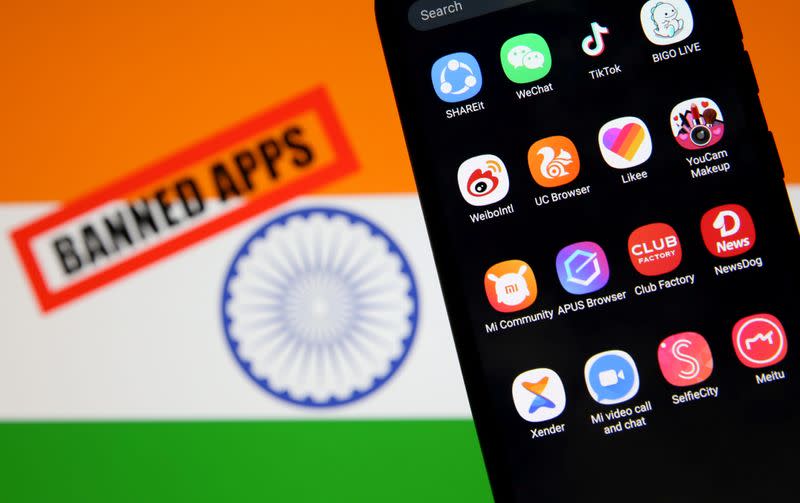 FILE PHOTO: Smartphone with Chinese applications is seen in front of a displayed Indian flag and a "Banned app" sign