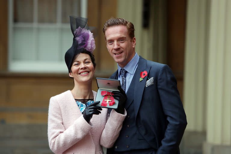 Helen McCrory y su esposo Damian Lewis en el palacio de  Buckingham cuando fue condecorada por la reina por su contribución a las artes escénicas