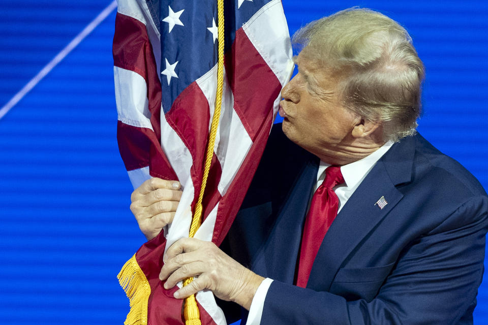 FILE - Republican presidential candidate former President Donald Trump kisses the flag as arrives to speak during the Conservative Political Action Conference, CPAC 2024, at National Harbor, in Oxon Hill, Md., Feb. 24, 2024. The Republican Party is aligning with Latin American populists as a way of injecting star power and the political landscape of immigrants' home countries into this year's U.S. election. (AP Photo/Alex Brandon, File)