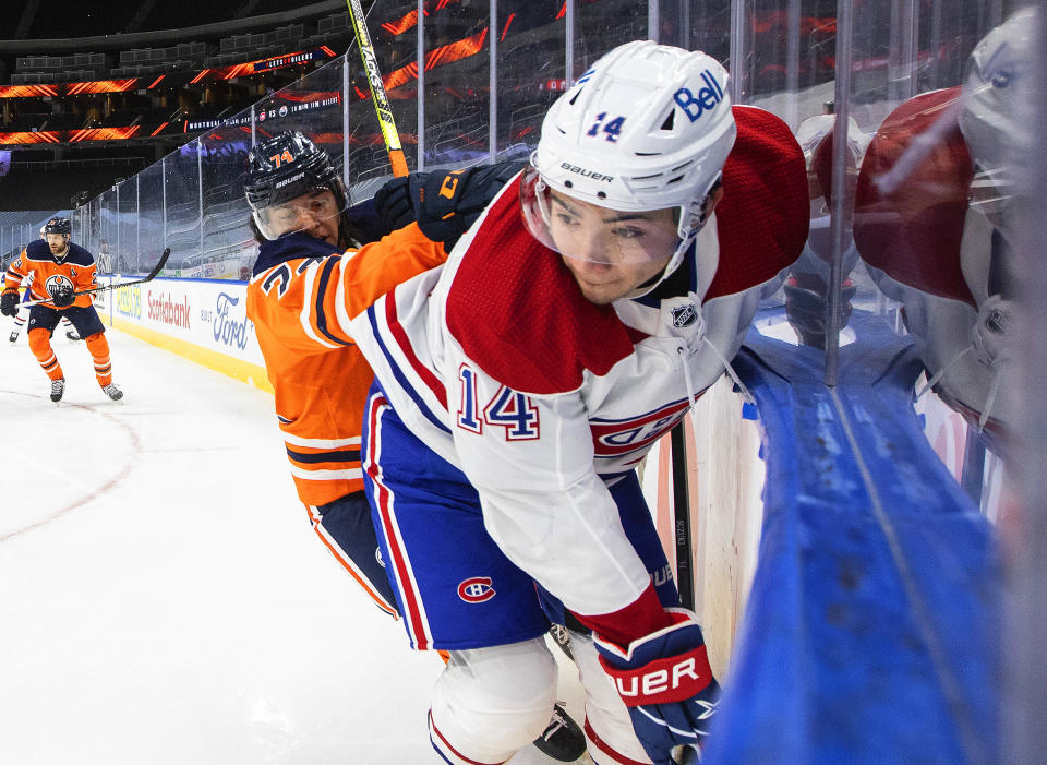 Edmonton Oilers' Ethan Bear (74) checks Montreal Canadiens' Nick Suzuki (14) during first-period NHL hockey game action in Edmonton, Alberta, Saturday, Jan. 16, 2021. (Jason Franson/The Canadian Press via AP)