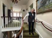 FILE - In this undated file photo provided by her family, Margaret Payne poses for a photo on the stairs of her home in Sutherland, Scotland. The legacy of Capt. Tom Moore, the super fundraiser who died Tuesday, Feb. 2, 2021 of COVID-19, lives on in many people. Payne, 90, walked up the stairs in her home 282 times to raise 416,000 pounds for the NHS. Payne, from Ardvar in the Scottish Highlands, calculated that the feat was the equivalent of climbing 731 meters (2,398 feet), or the height of Suilven, one of Scotland's best known mountains that she scaled when she was 15.(Payne Family via AP, File)