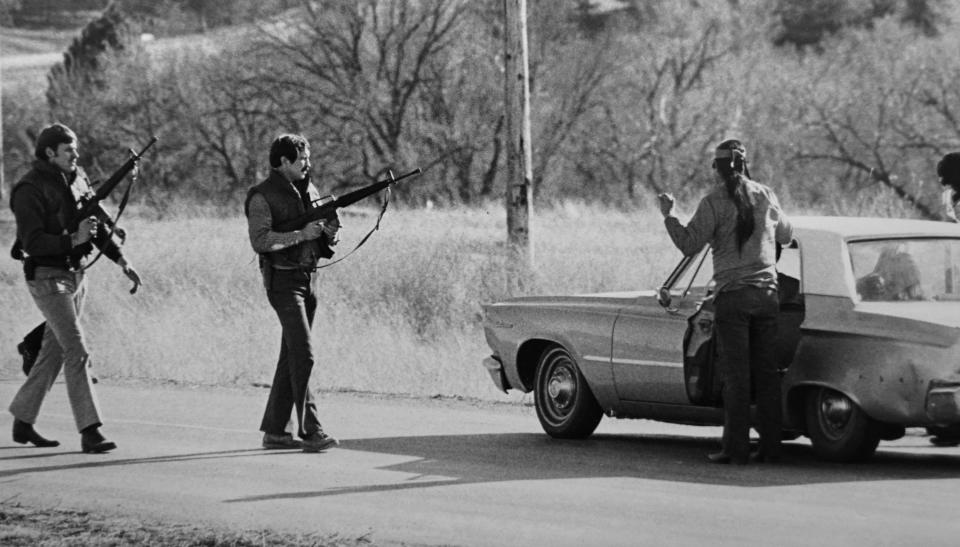 FILE - FBI agents stop a man at a roadblock near Wounded Knee, S.D., in 1973. (AP Photo/Jim Mone, File)