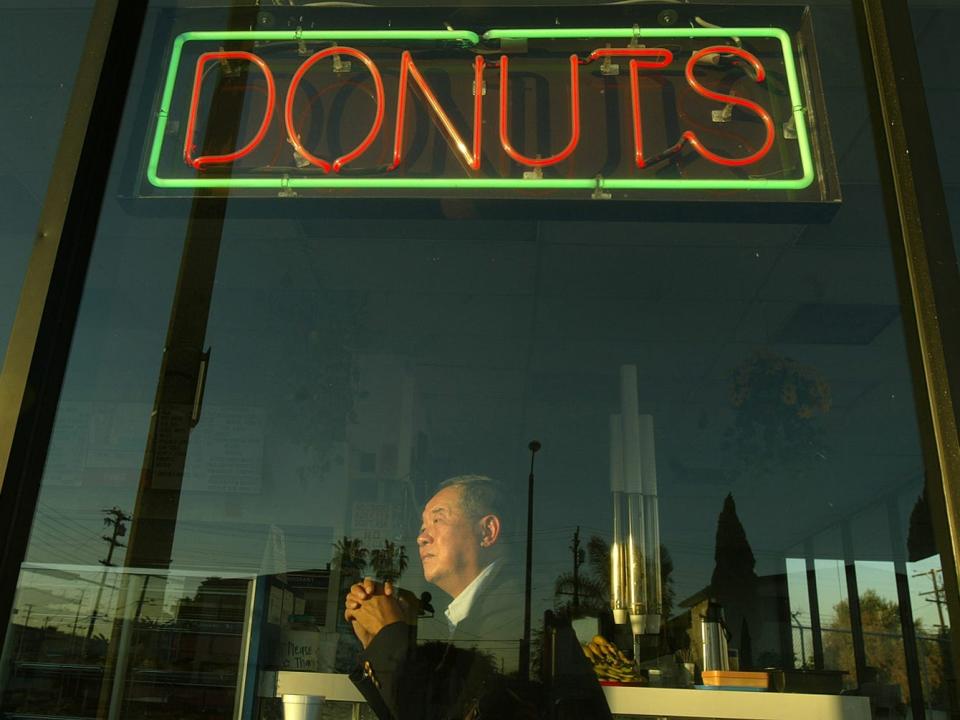 Ted Ngoy sits in one of his donut shops