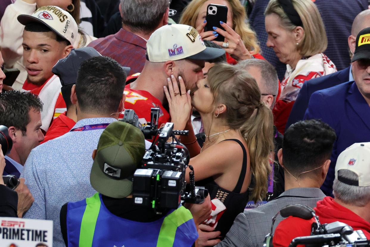 Travis Kelce of Kansas City Chiefs kisses Taylor Swift