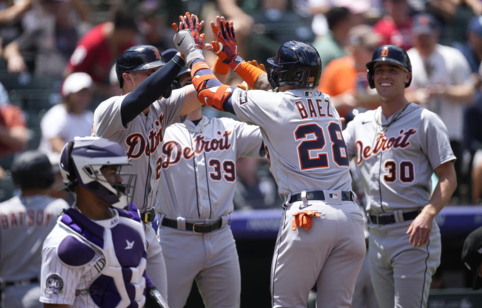 Detroit Tigers' Javier Baez (28) is congratulated by, from back left to right, Spencer Torkelson, Zach McKinstry and Kerry Carpenter after hitting a grand slam in the first inning of a baseball game against the Colorado Rockies, Sunday, July 2, 2023, in Denver. (AP Photo/David Zalubowski)