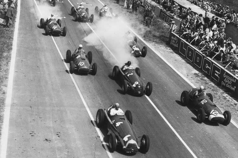 Juan Manuel Fangio conduciendo el Alfa Romeo SpA Alfa Romeo 159A número 4 lidera la carrera, lejos de Alberto Ascari en el Ferrari 375 de la Scuderia Ferrari número 12 en el inicio del Gran Premio de Francia del ACF, el 1 de julio de 1951 en Reims, Francia.