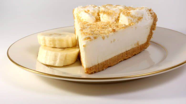 Banana cream pie on white and gold plate