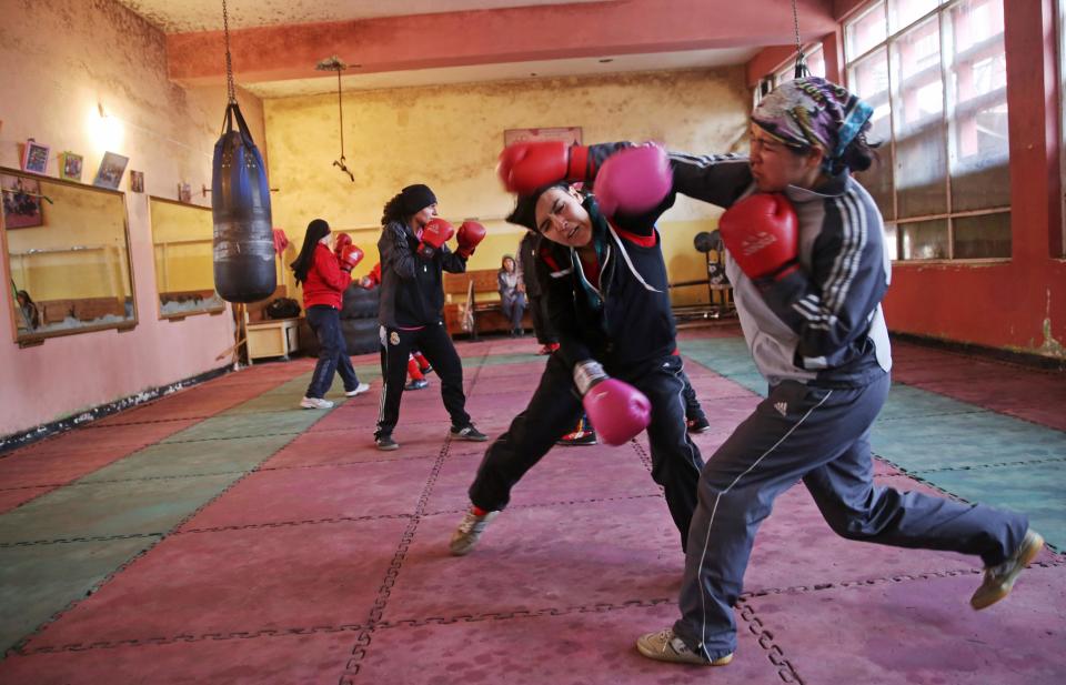 In this Wednesday, March, 5, 2014 photo, Afghan women boxers practice at the Kabul stadium boxing club. A few yellow lamps light up the cavernous, sparsely furnished room where Afghanistan’s young female boxers train, hoping to become good enough to compete in the 2016 Olympics. (AP Photo/Massoud Hossaini)