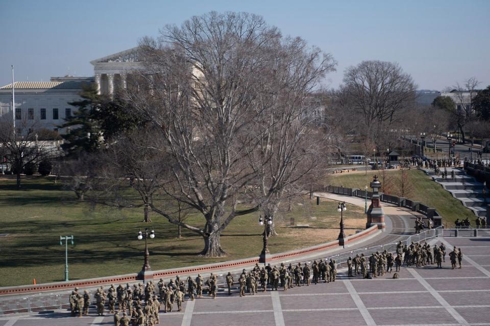 <p>Members of the National Guard guard Capitol Hill grounds in Washington, DC, January 13, 2021.</p>