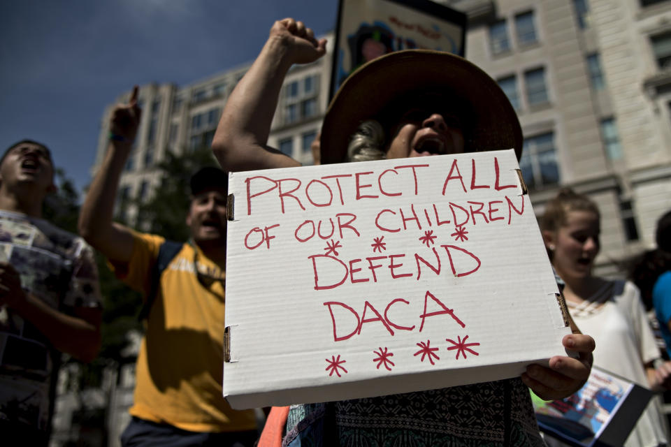 A demonstrator yells while holding a sign protesting the end of the DACA program outside Trump International Hotel in Washington, D.C. on Tuesday. (Photo: Bloomberg via Getty Images)