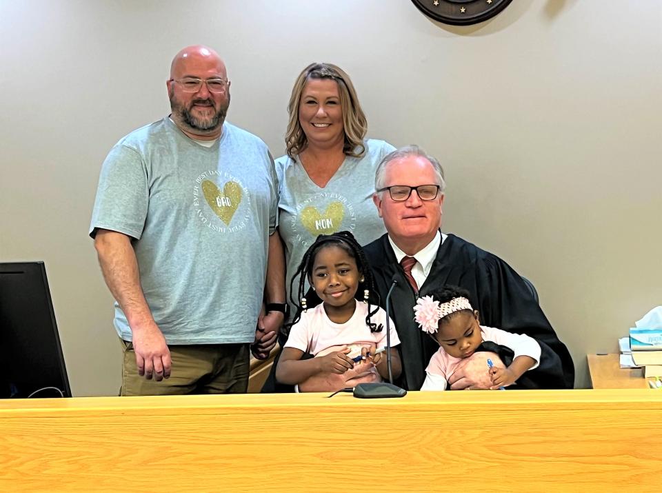 Rob and Rachelle Howard stand with Judge Mark Feyen and their newly adopted children Aleah and Delilah after their adoption was confirmed Tuesday, Nov. 22, 2022.
