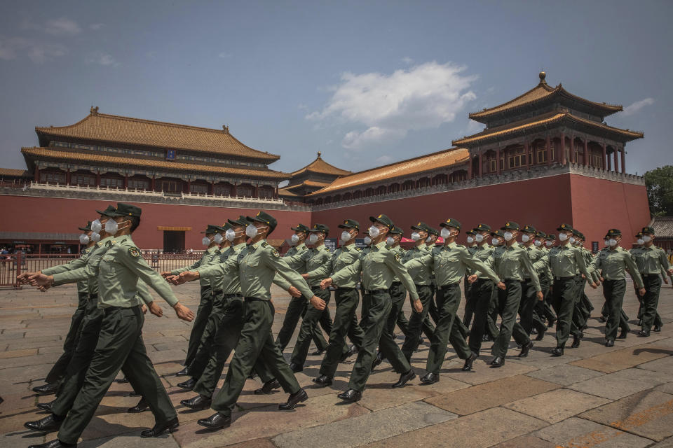 Chinese People's Liberation Army (PLA) soldiers wearing protective face masks march past the entrance to the Forbidden City on the first day of China's National People's Congress (NPC) in Beijing, Friday, May 22, 2020. China held the Chinese People's Political Consultative Conference (CPPCC) on Thursday and the NPC on Friday, after the two major political meetings initially planned to be held in March, 2020 were postponed amid the ongoing new coronavirus  pandemic.  (Roman Pilipey/Pool Photo via AP)