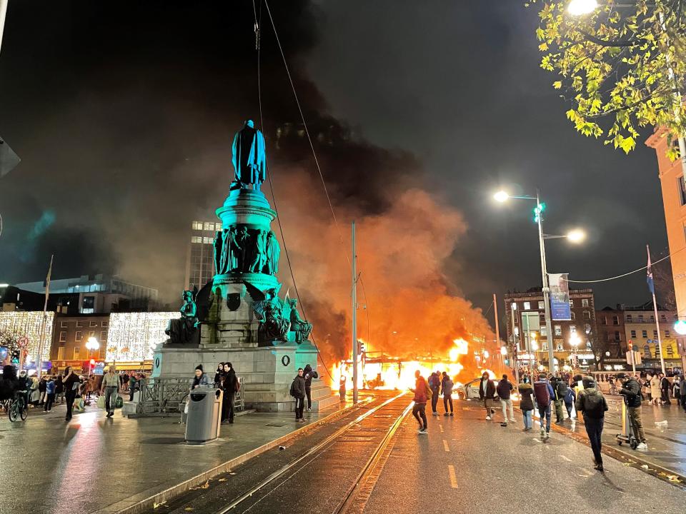 A bus and car on fire on O'Connell Street in Dublin city centre after violent scenes unfolded following an attack on Parnell Square East where five people were injured, including three young children.