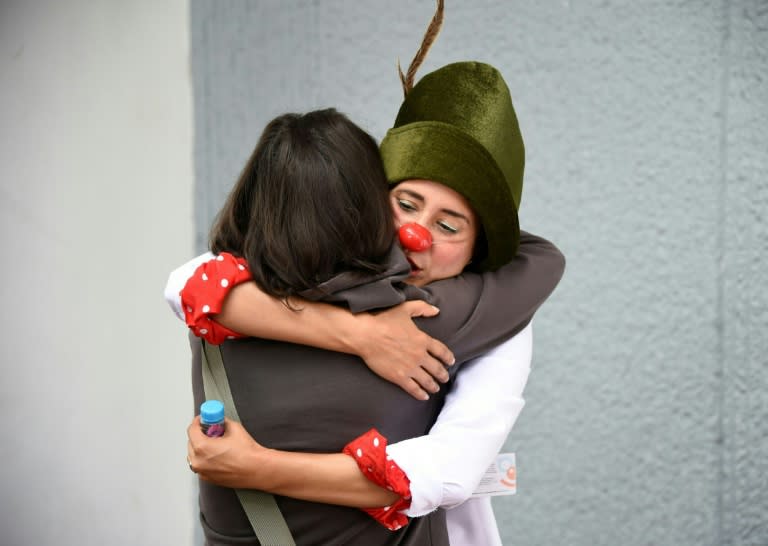 Therapists and psychologists dressed as clowns in white overalls offer their support to Mexico City families whose houses were damaged during the September 19 quake and cannot return home