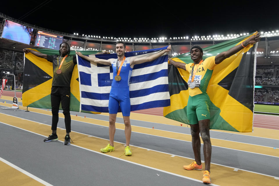 Bronze medalist Tajay Gayle, of Jamaica, gold medalist Miltiadis Tentoglou, of Greece, and silver medalist Wayne Pinnock, of Jamaica, from left, pose after the Men's long jump final during the World Athletics Championships in Budapest, Hungary, Thursday, Aug. 24, 2023. (AP Photo/Matthias Schrader)