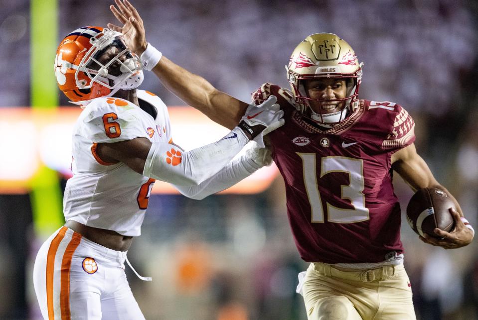 Florida State Seminoles quarterback Jordan Travis (13) stiff arms Clemson Tigers cornerback Sheridan Jones (6).The Clemson Tigers defeated the Florida State Seminoles 34-28 at Doak Campbell Stadium on Saturday, Oct. 15, 2022.