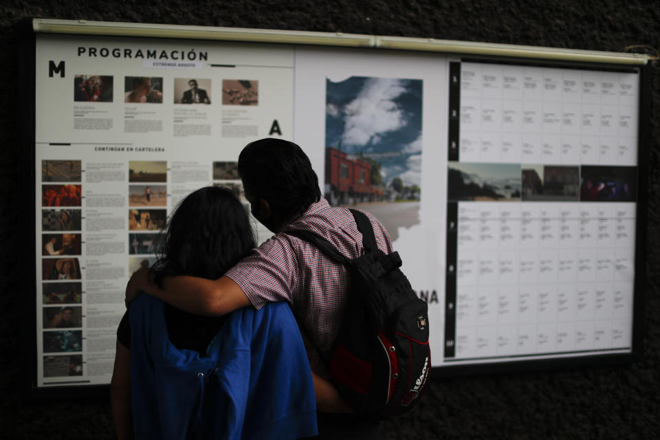 Una pareja lee la cartelera en la Cineteca Nacional en la Ciudad de México el miércoles 12 de agosto de 2020. Después de estar cerrados casi cinco meses los cines reabrieron en la capital a 30% de capacidad.(Foto AP/Rebecca Blackwell)