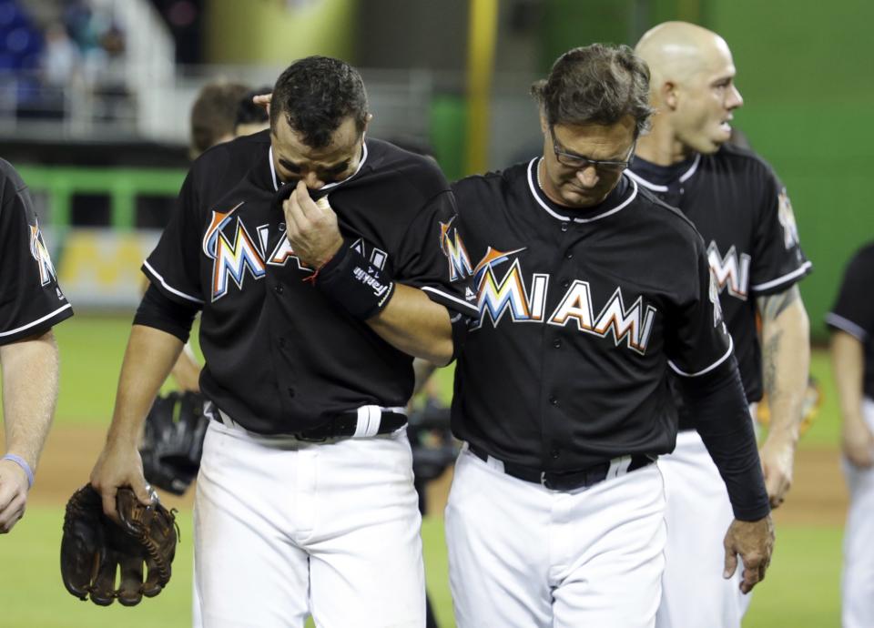 <p>Miami Marlins’ Martin Prado, left, walks off the field with manager Don Mattingly, right, after a baseball game against the New York Mets, Monday, Sept. 26, 2016, in Miami. The Marlins defeated the Mets 7-3. The Marlins pitcher Jose Fernandez was honored during the game. Fernandez was killed in a boating accident early Sunday. (AP Photo/Lynne Sladky) </p>